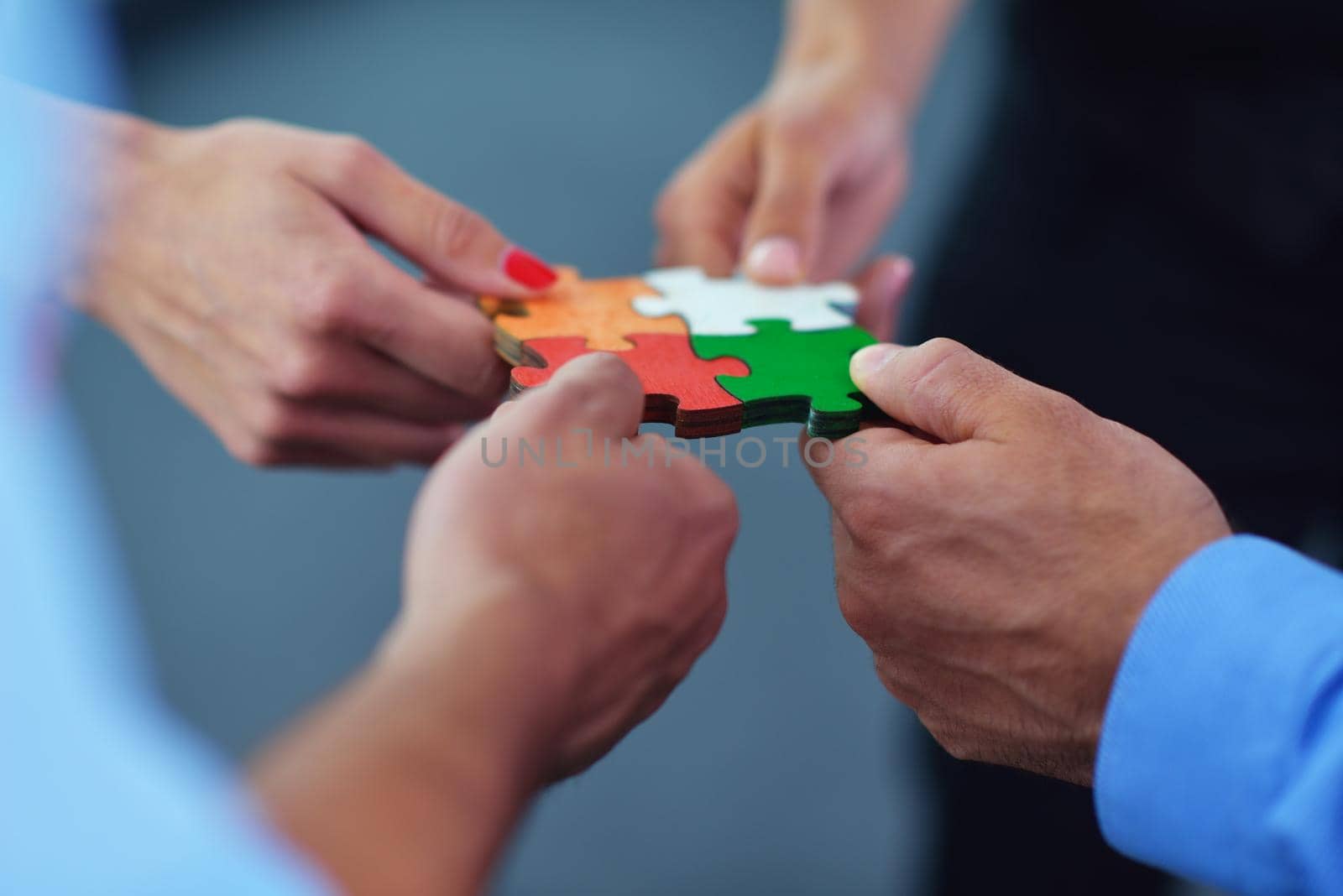 Group of business people assembling jigsaw puzzle by dotshock