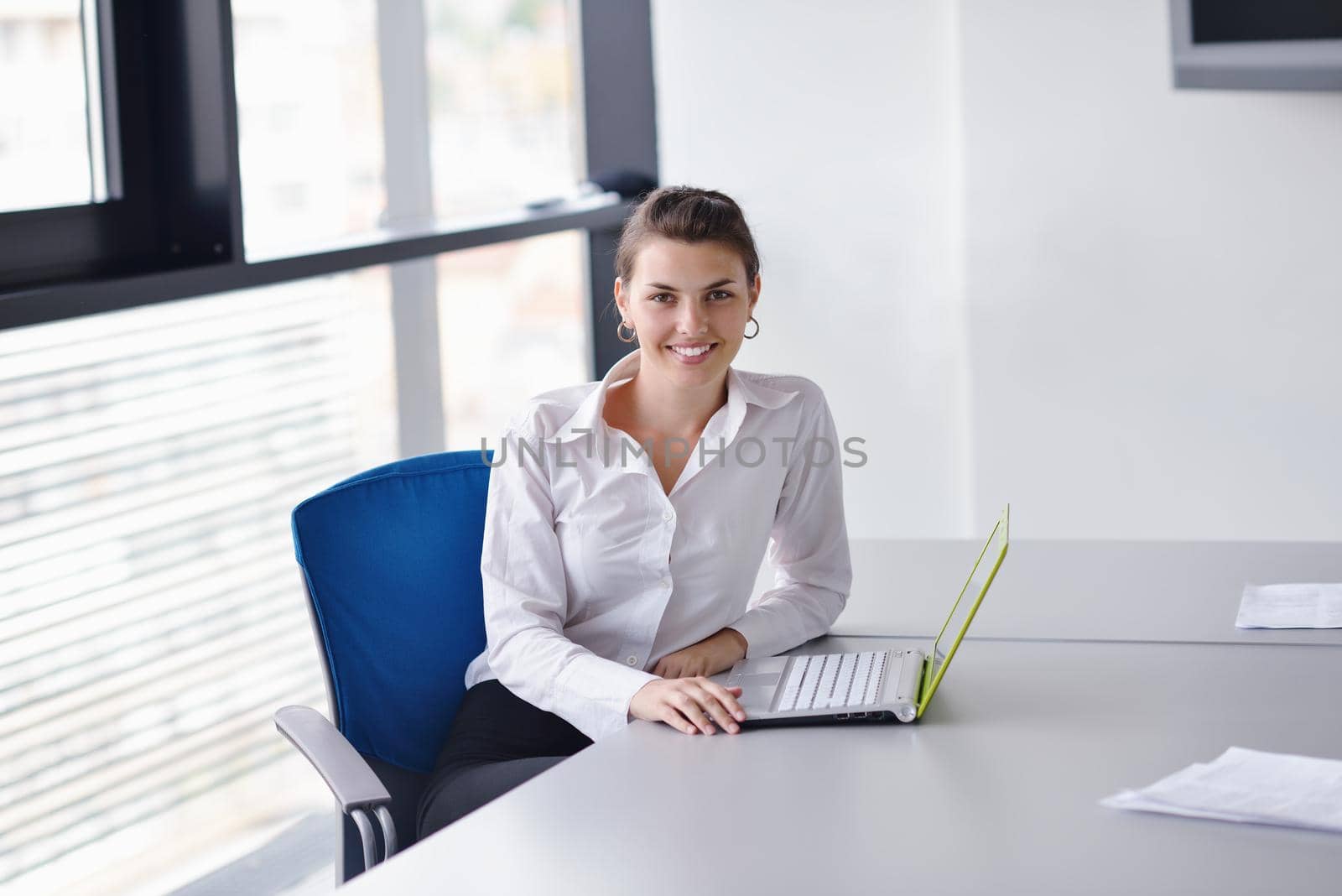 Young pretty business woman with notebook in the bright modern office indoors