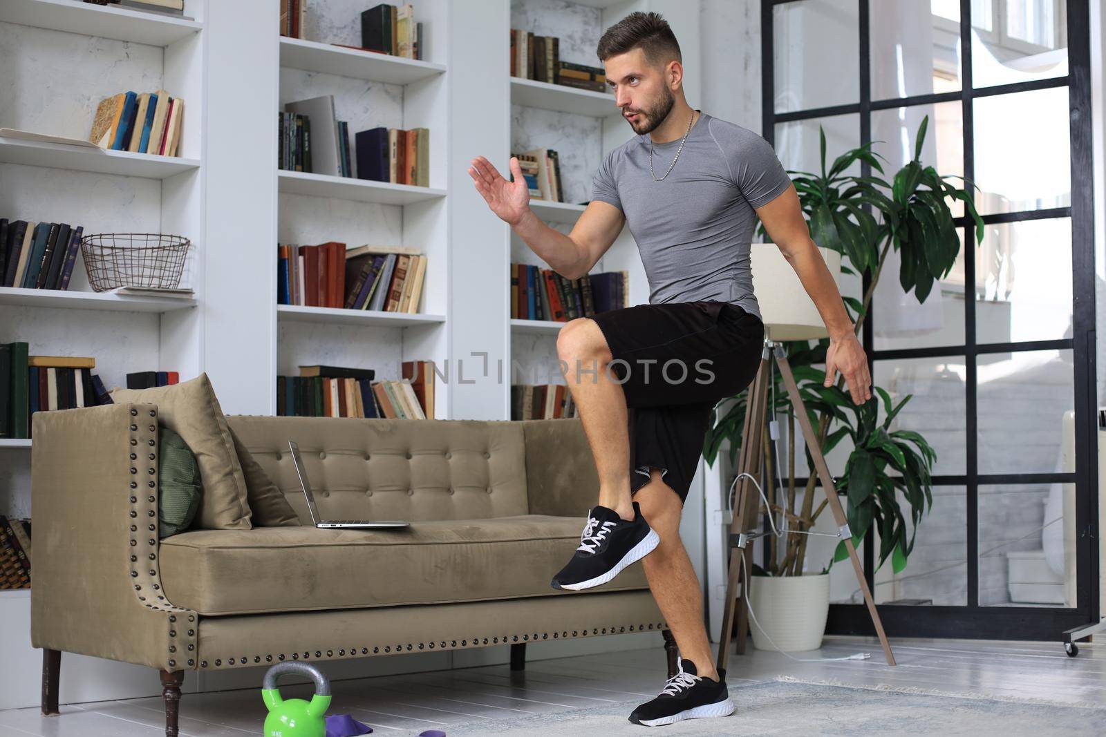 Handsome man doing sport exercise at home during quarantine. Concept of healthy life