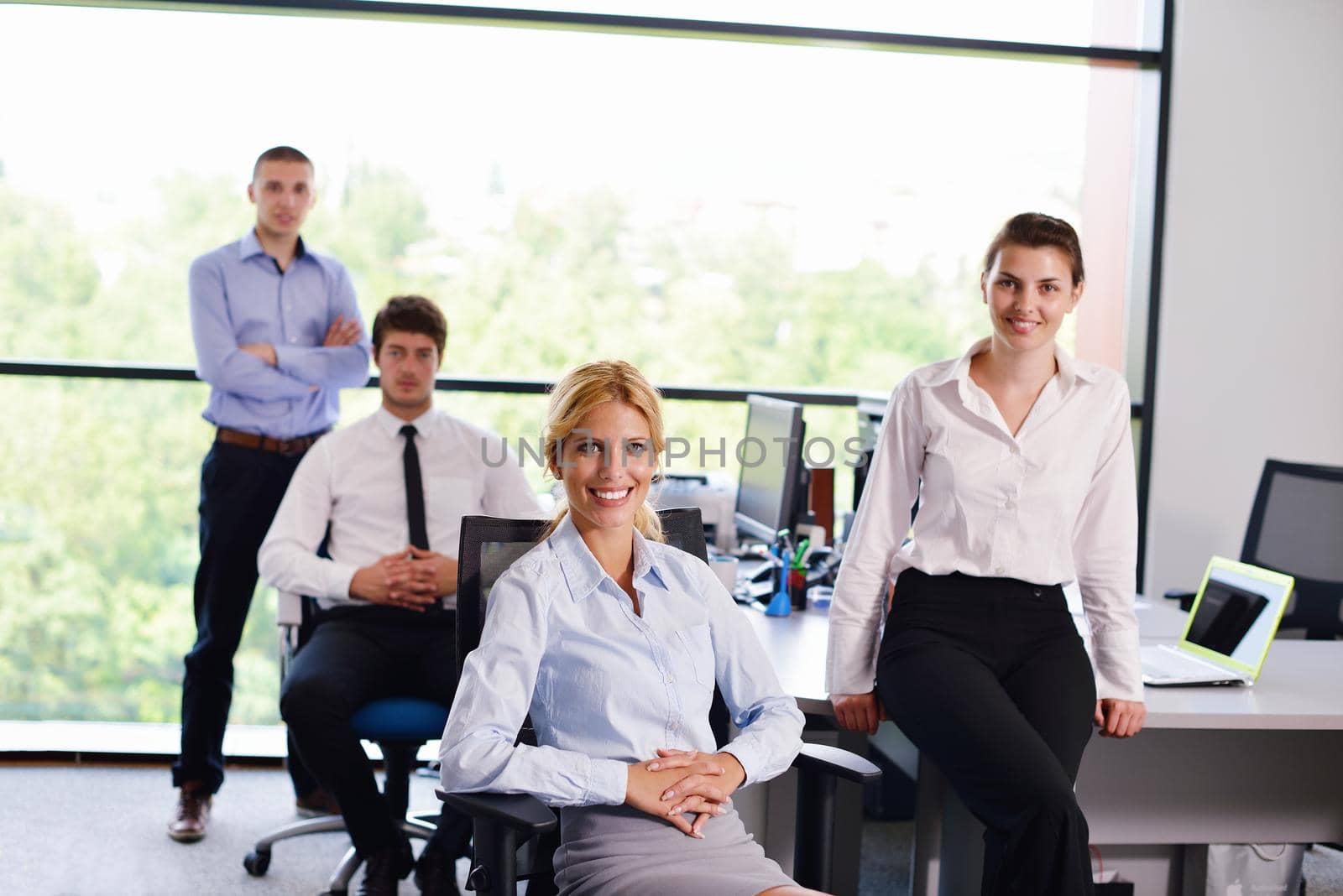 business woman with her staff in background at office by dotshock