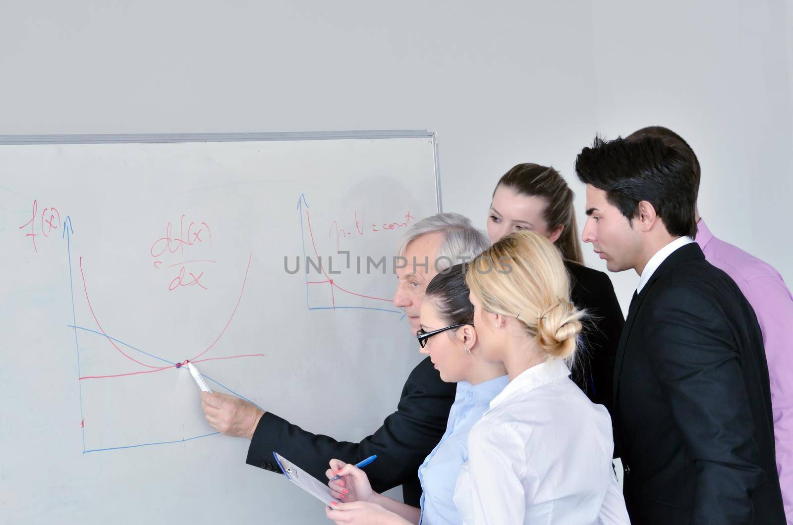 Senior male business man giving a presentation at a  meeting at modern light office on a table board