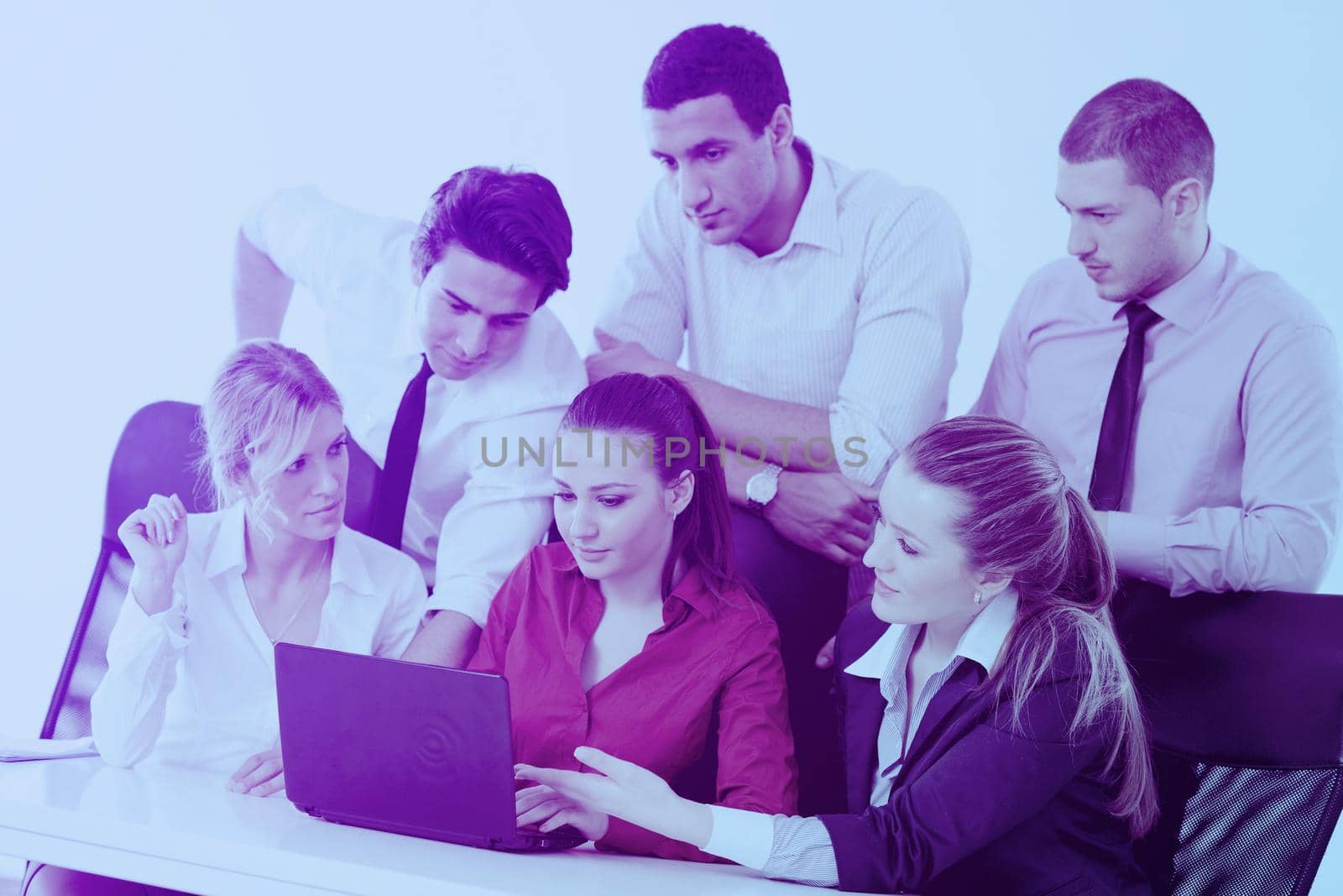 Group of young business people sitting in board room during meeting and discussing with paperwork