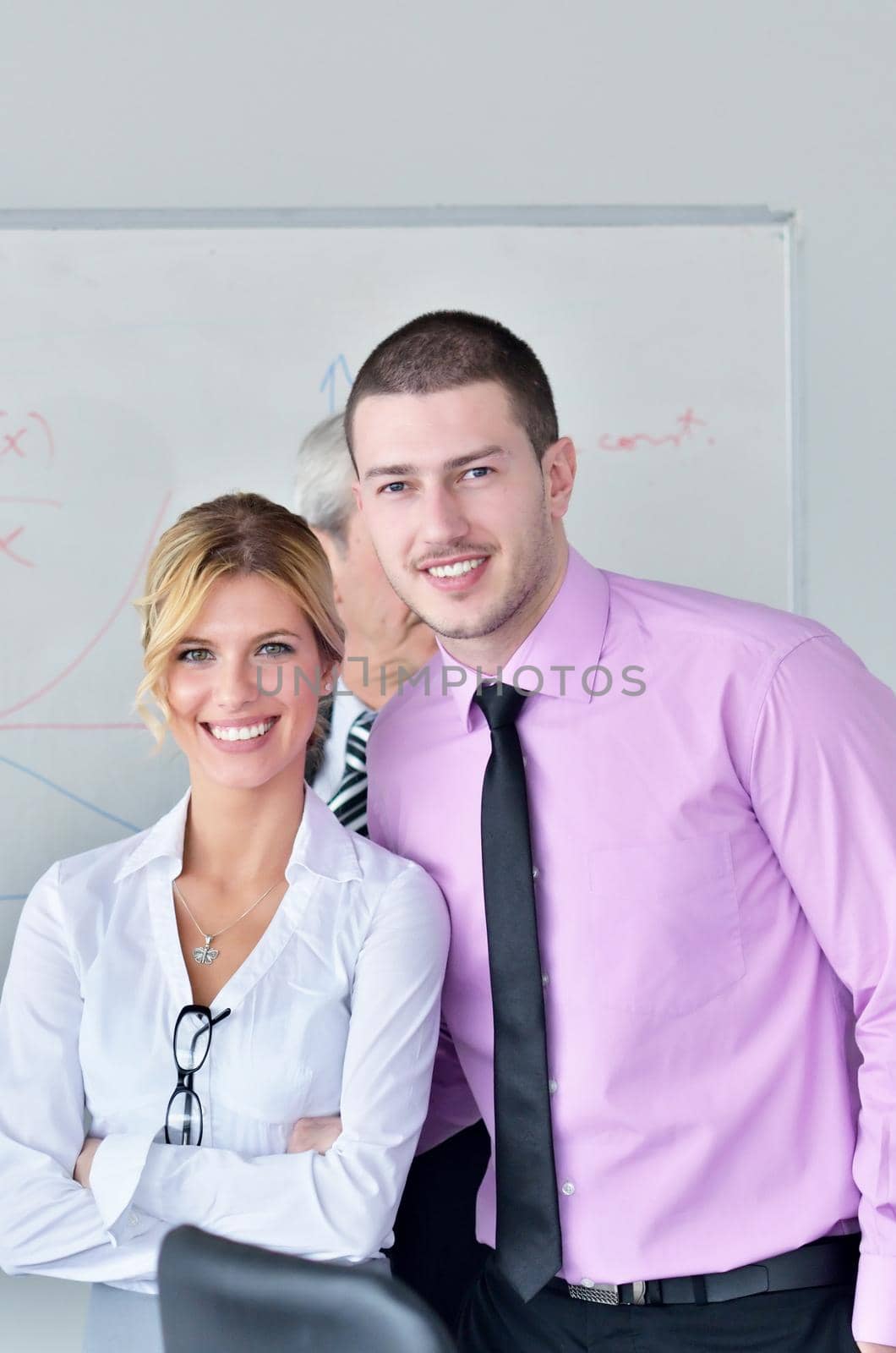 Group of young business people sitting in board room during meeting and discussing with paperwork