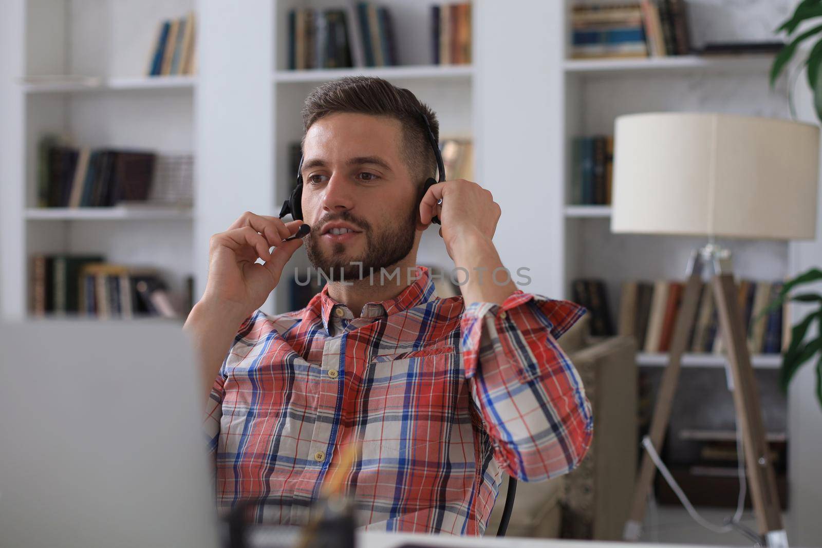 Smiling young business man having video call at home office