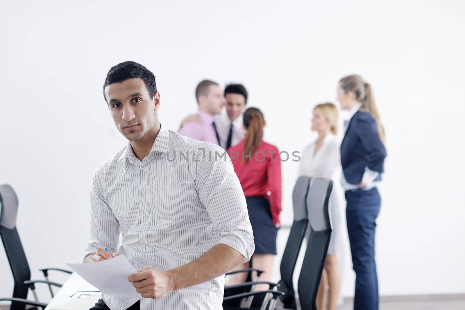 Confident young business man attending a meeting with his colleagues