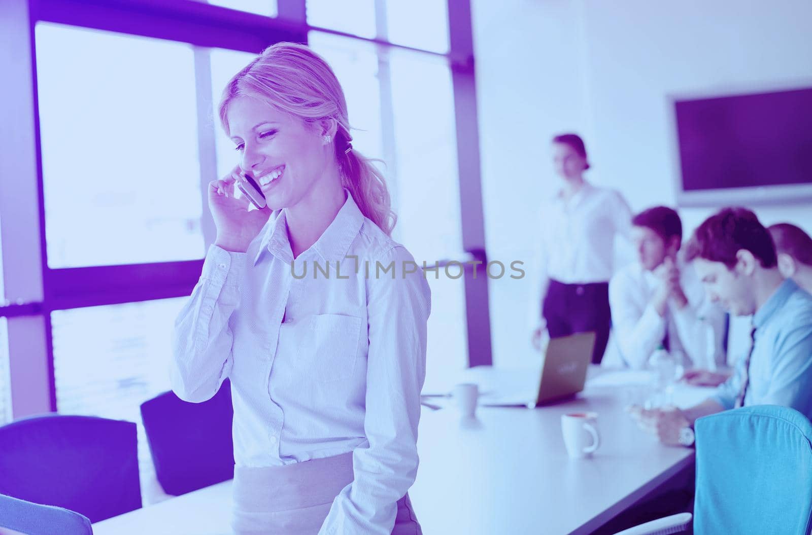 business woman with her staff in background at office by dotshock