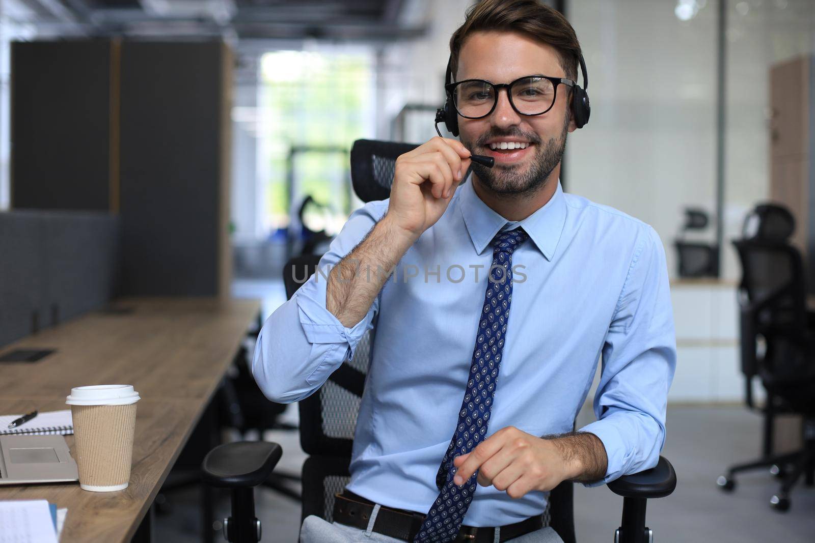 Smiling friendly handsome young male call centre operator