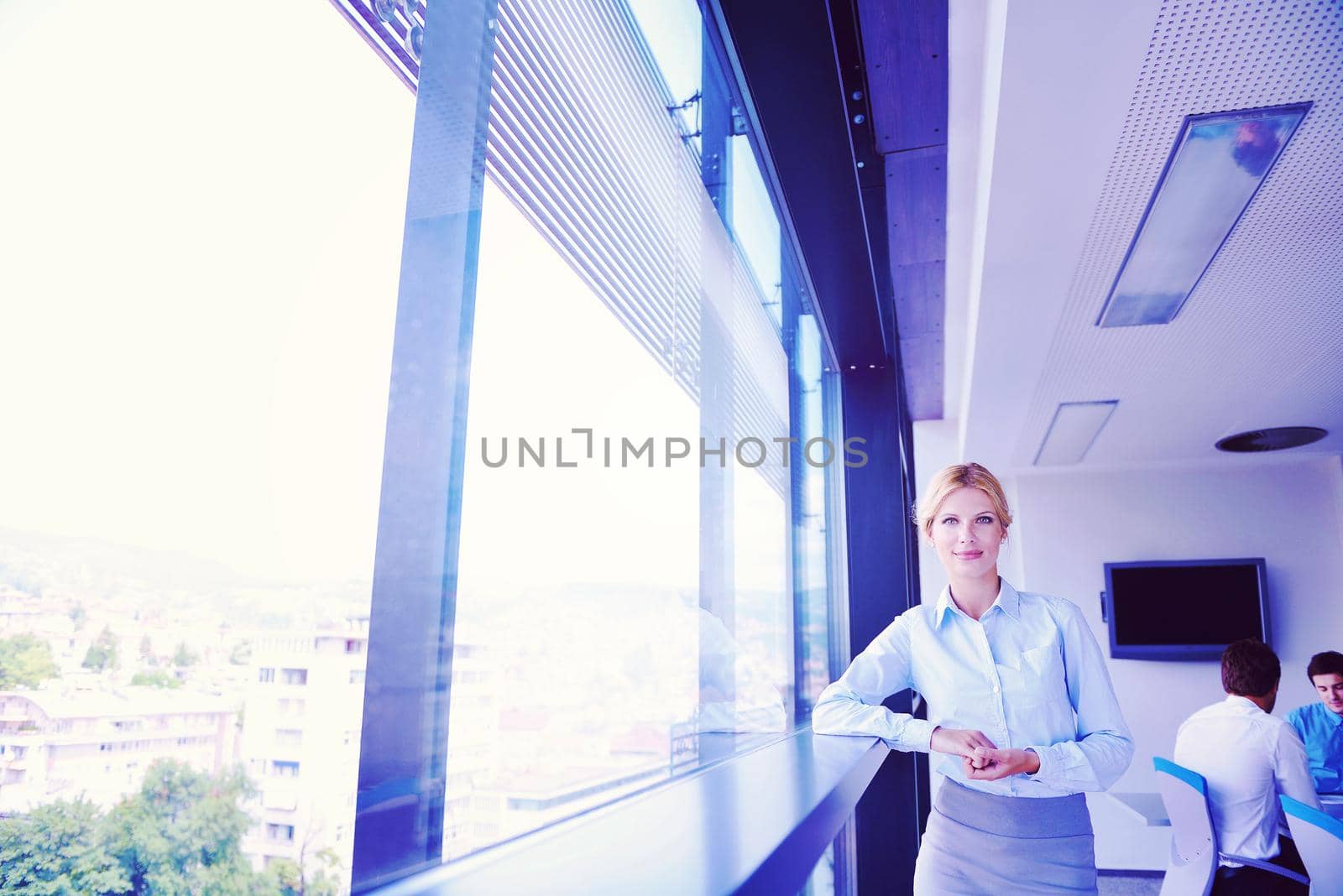 business woman with her staff in background at office by dotshock