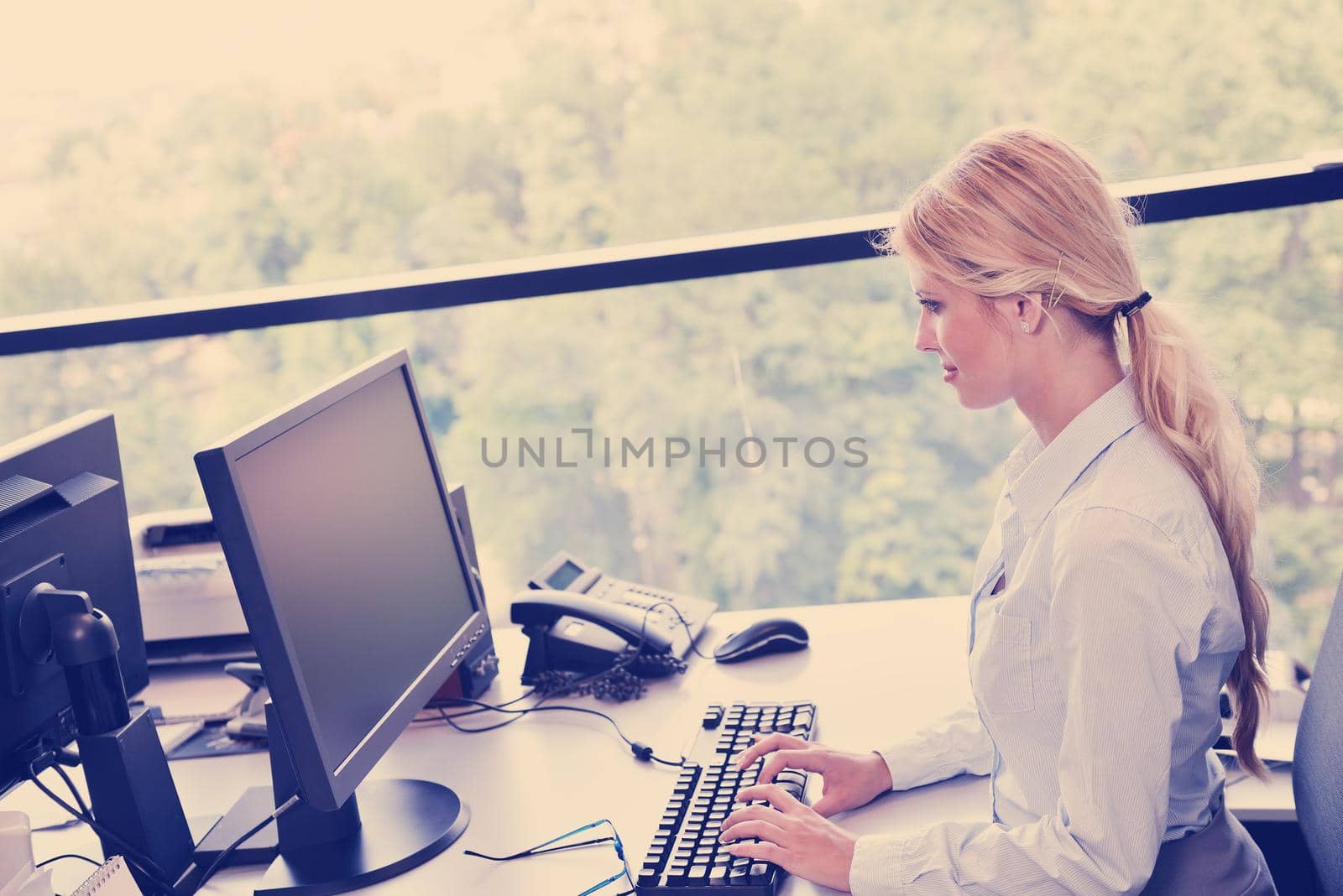 Young pretty business woman with notebook in the bright modern office indoors