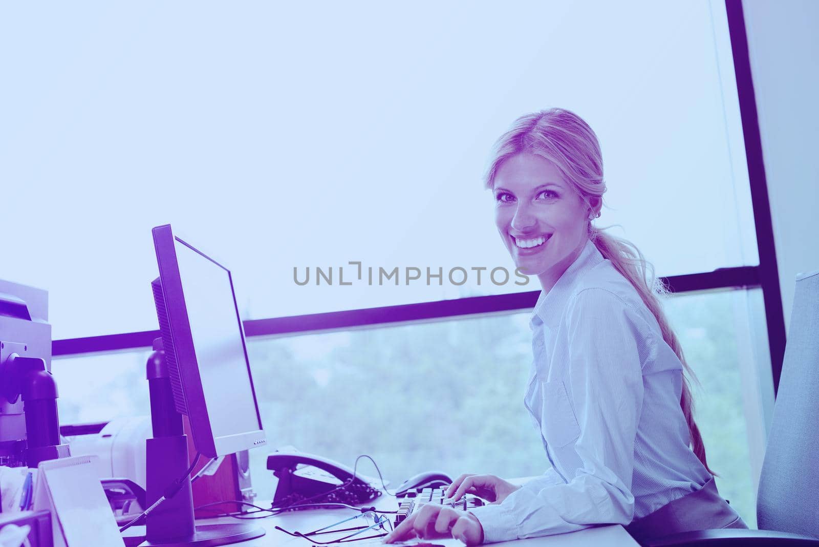 Portrait of a beautiful business woman working on her desk in an office environment.