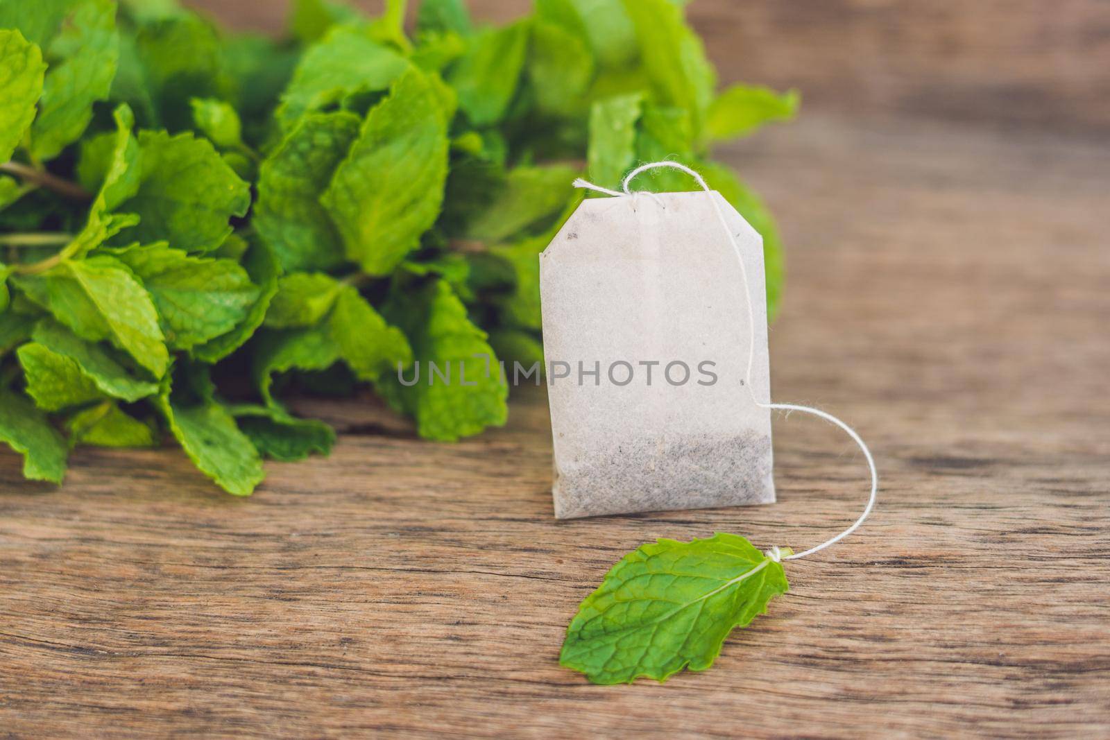 Tea bags on wooden background with fresh melissa, mint. Tea with mint concept by galitskaya