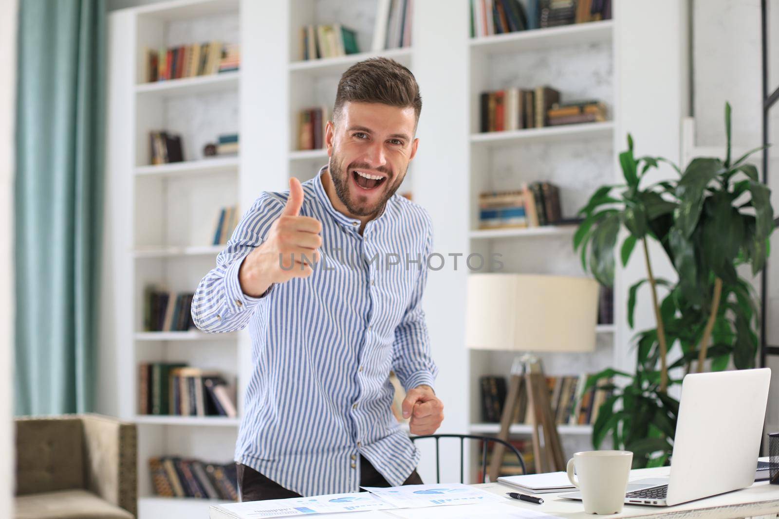 Businessman showing OK sign with his thumb up. Selective focus on face