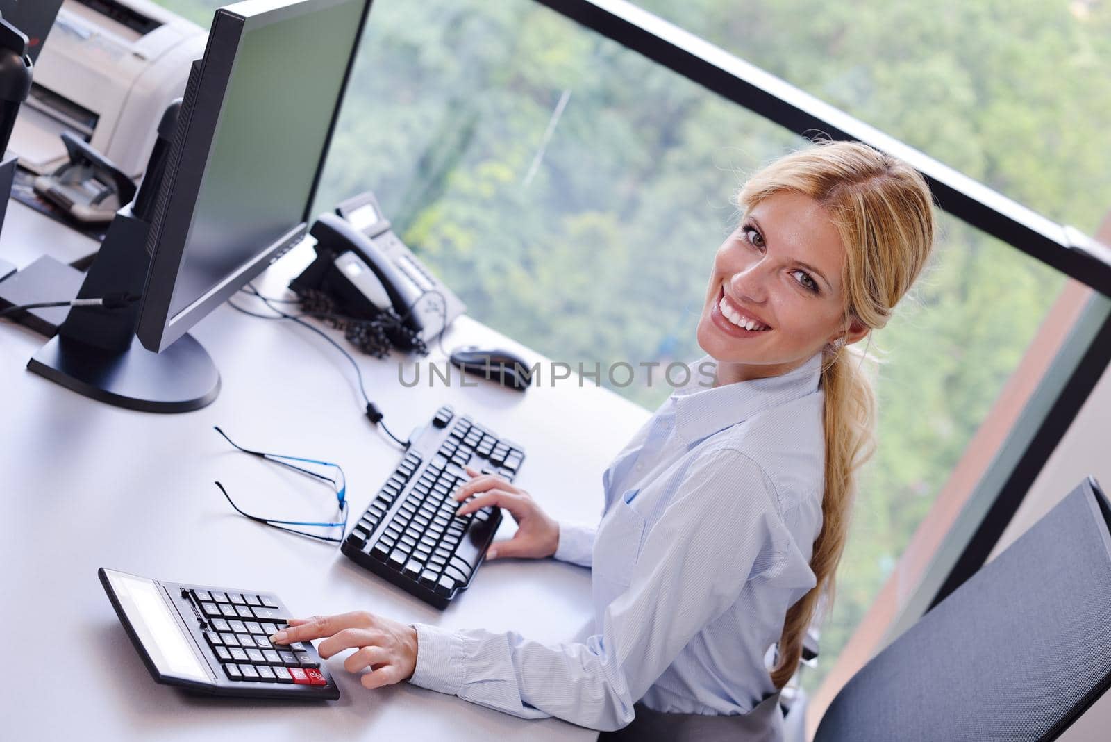 Portrait of a beautiful business woman working on her desk in an office environment.