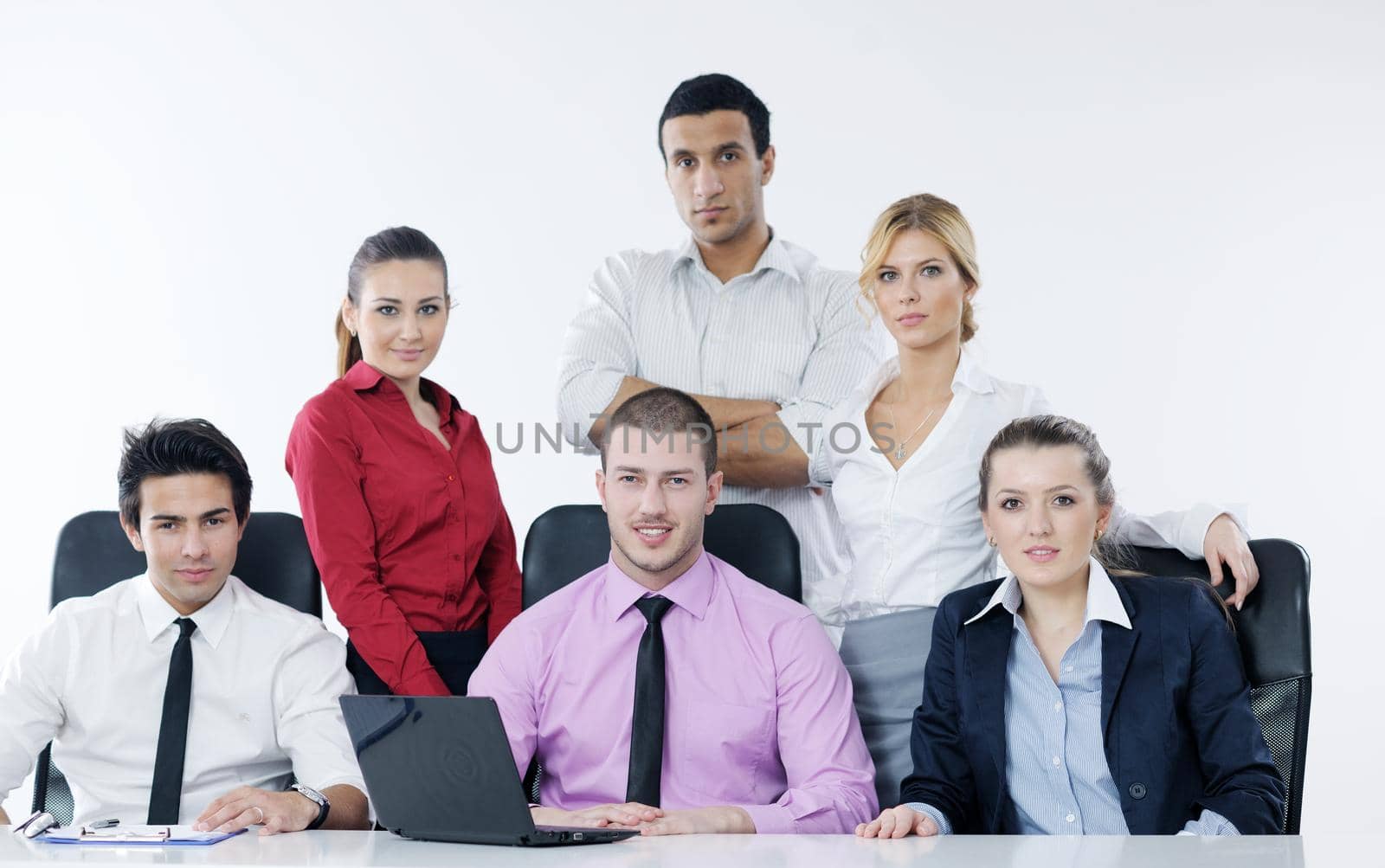 Group of young business people sitting in board room during meeting and discussing with paperwork