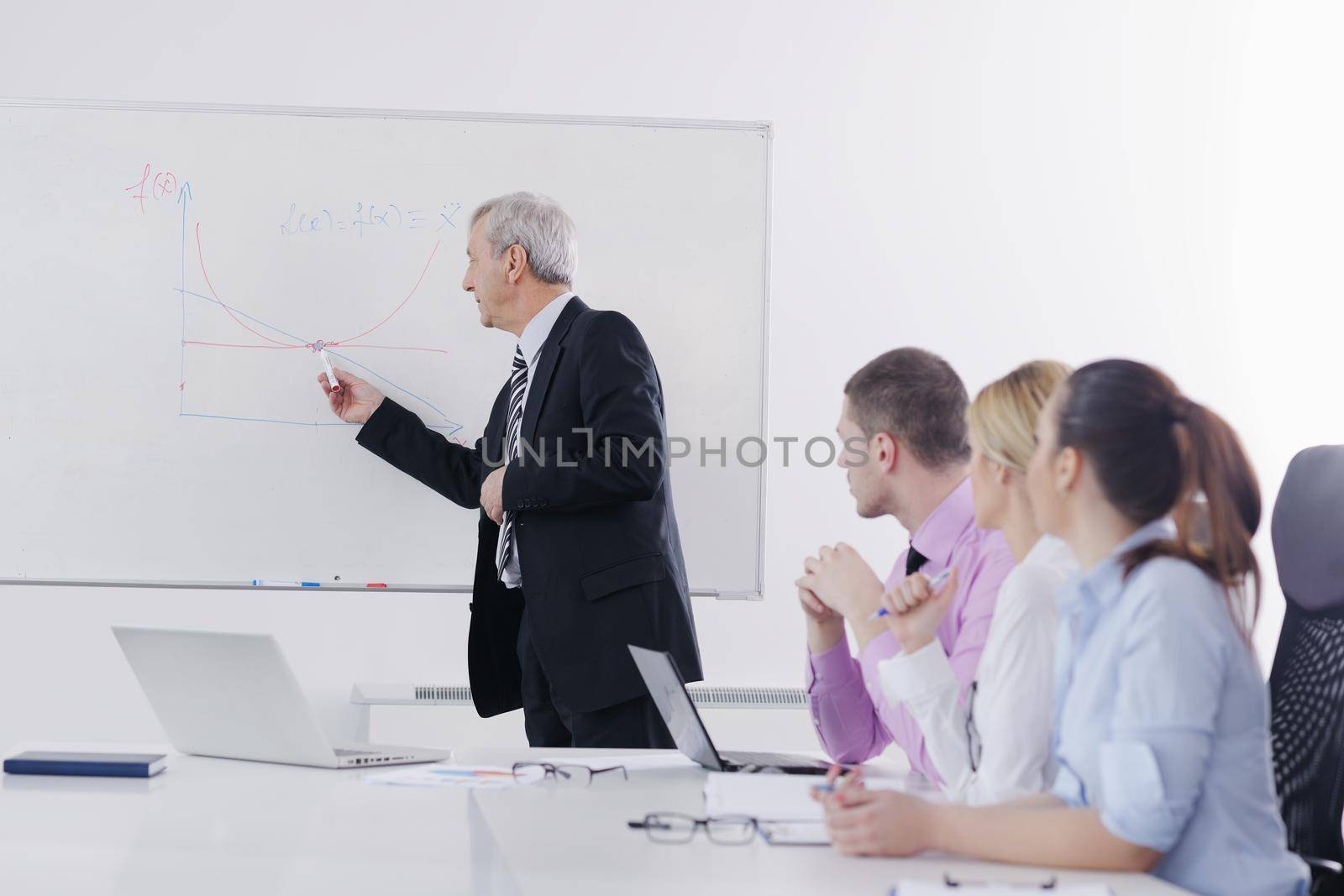 Senior business man giving a presentation by dotshock