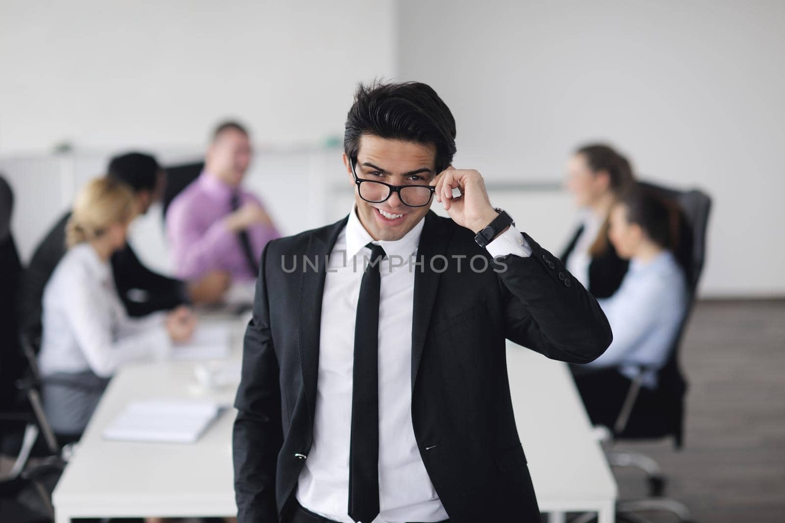 Confident young business man attending a meeting with his colleagues