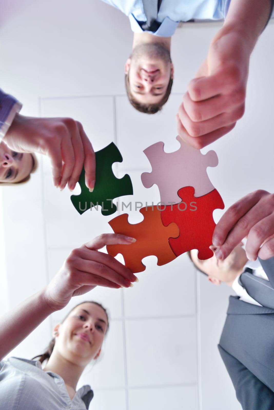 Group of business people assembling jigsaw puzzle by dotshock