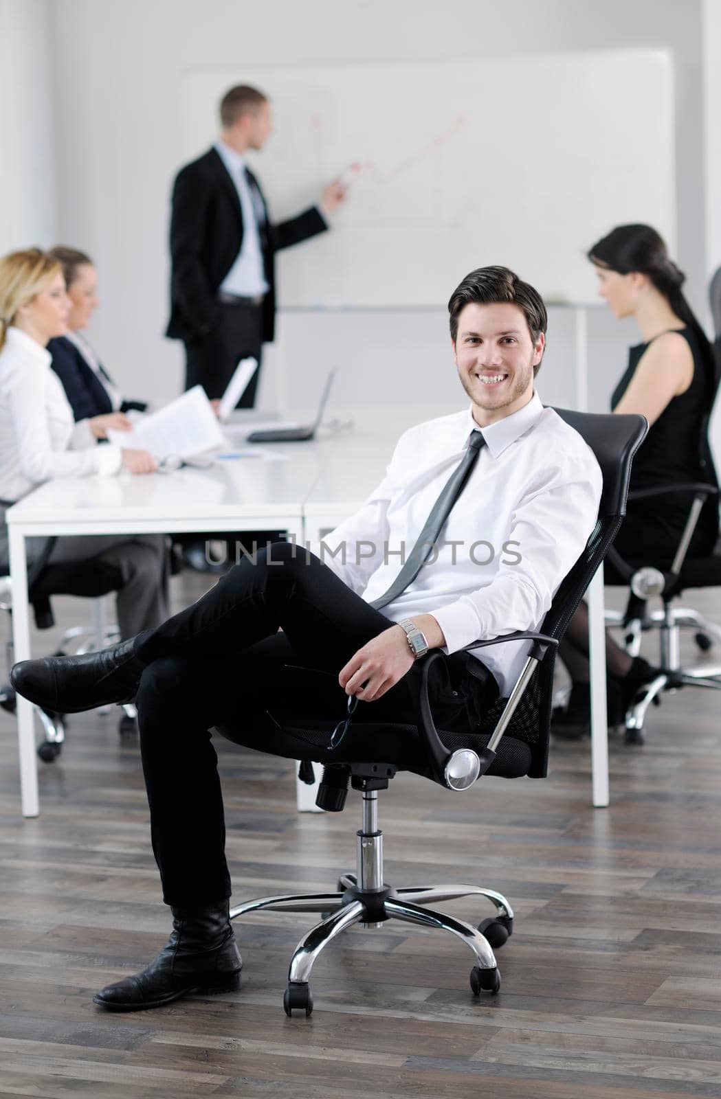 handsome young business man with colleagues in background by dotshock
