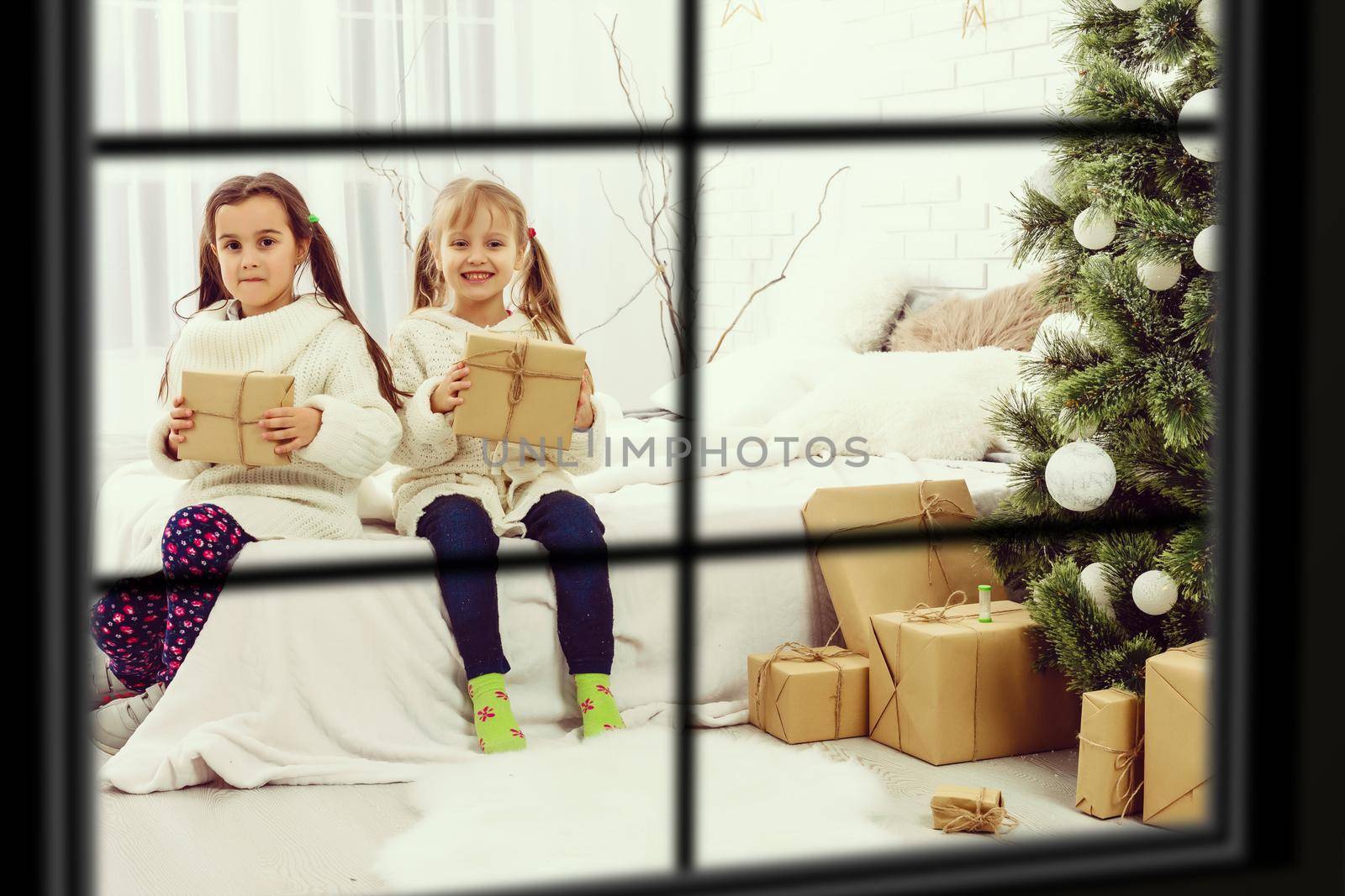Big family with three children celebrating Christmas at home. Festive dinner at fireplace and Xmas tree. Parent and kids eating at fire place in decorated room. Child lighting advent wreath candle