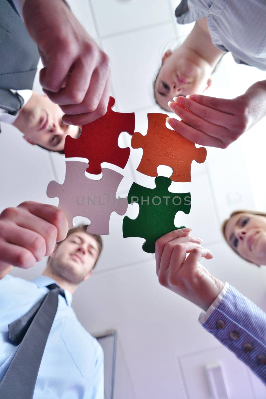 Group of business people assembling jigsaw puzzle by dotshock