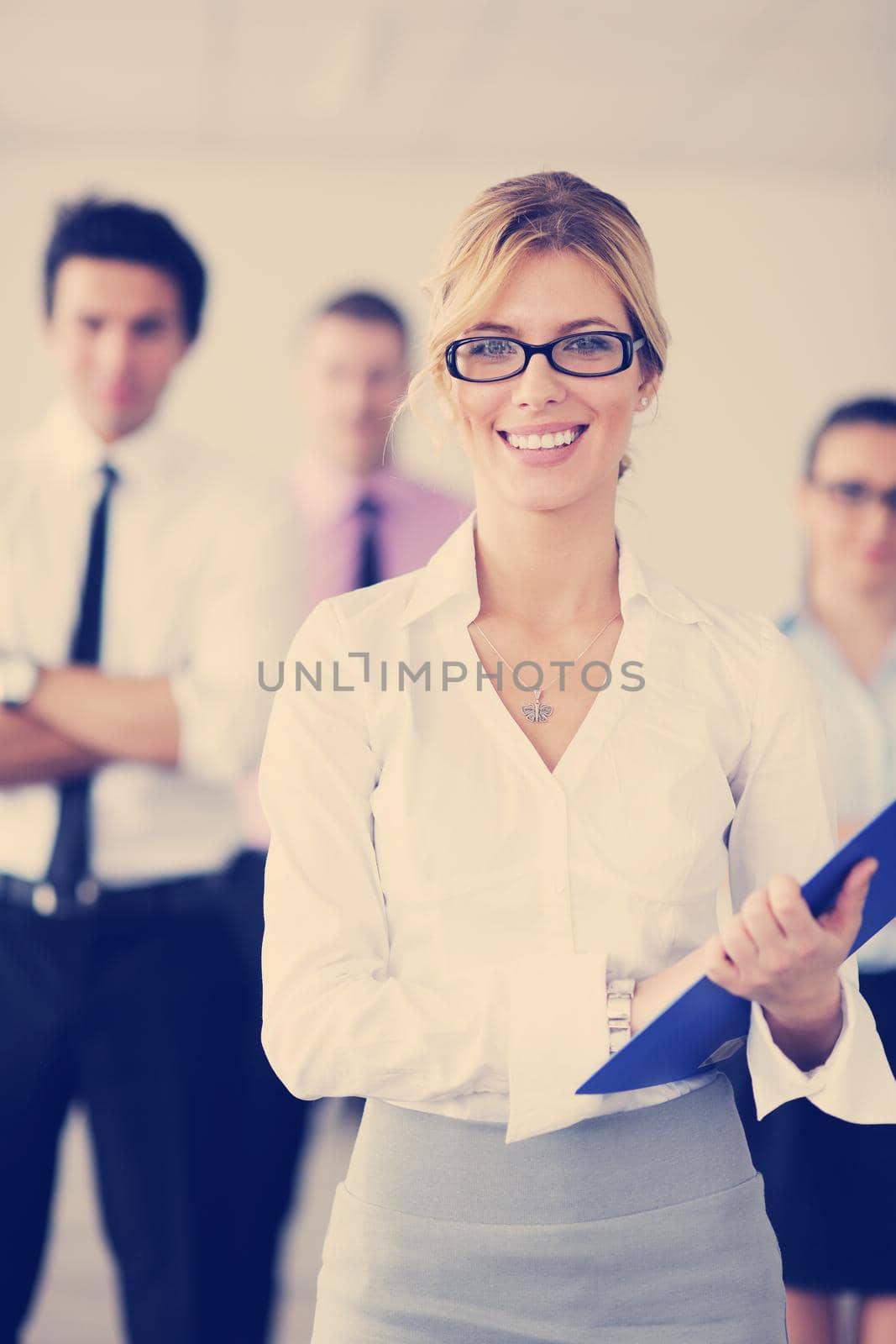 business woman standing with her staff in background by dotshock