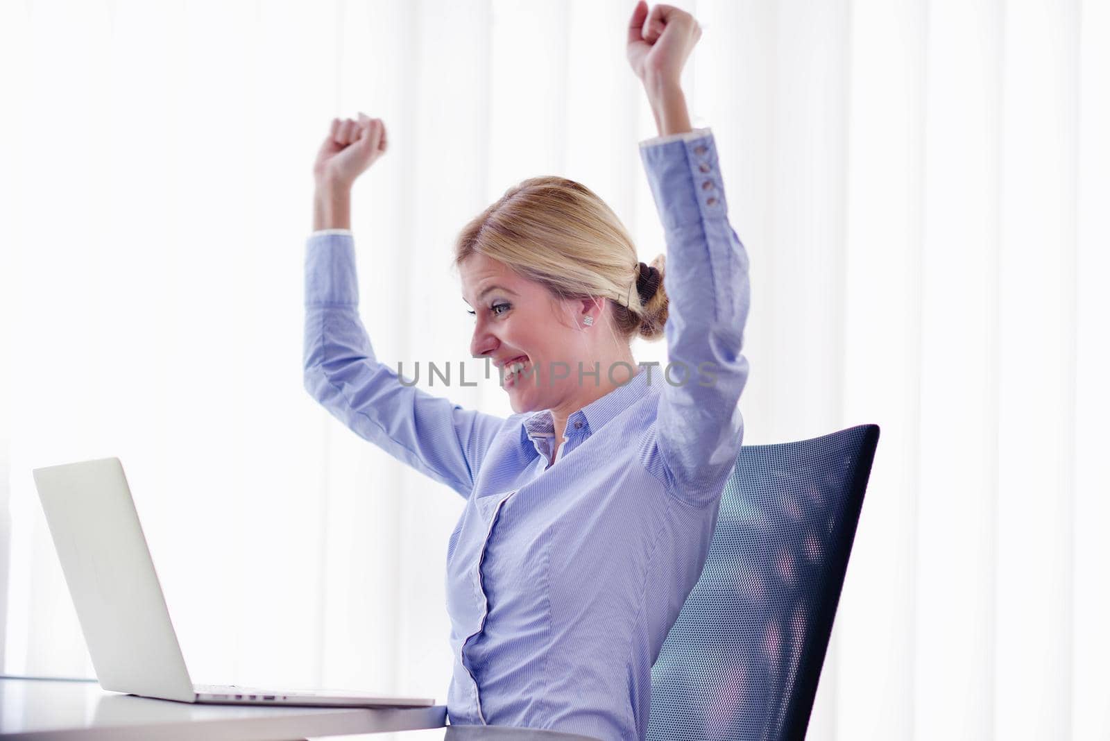 portrait of Young pretty business woman work on  notebook computer  in the bright modern office indoors