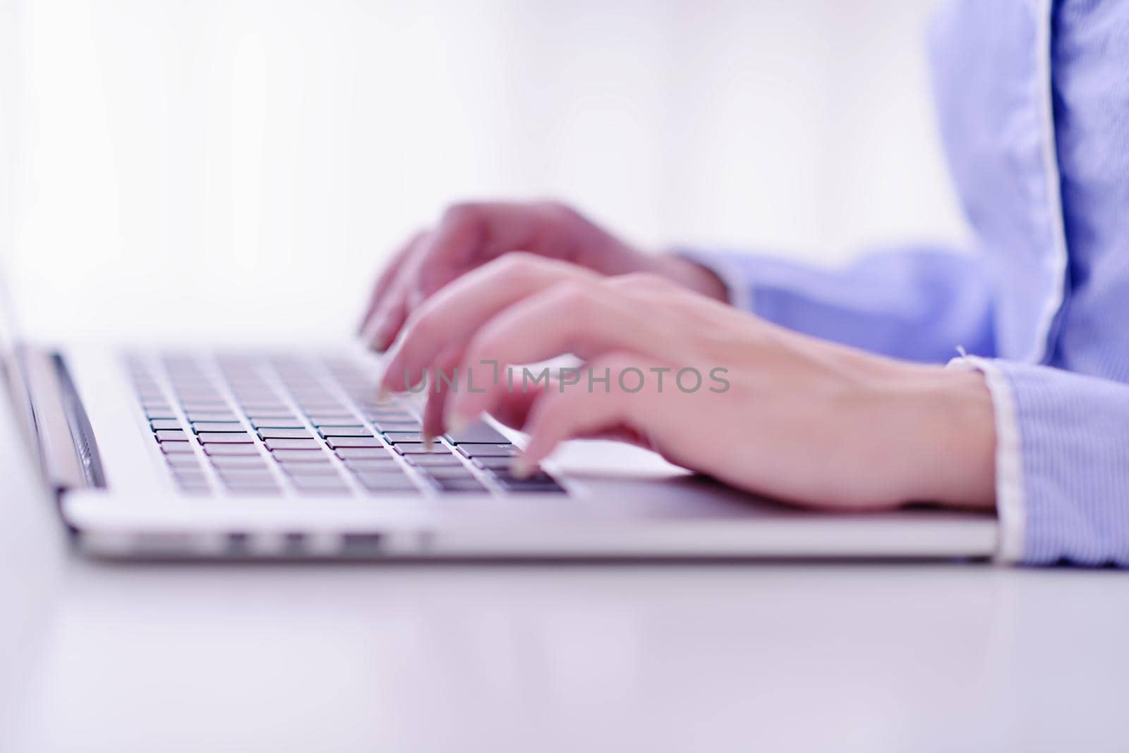 portrait of Young pretty business woman work on  notebook computer  in the bright modern office indoors