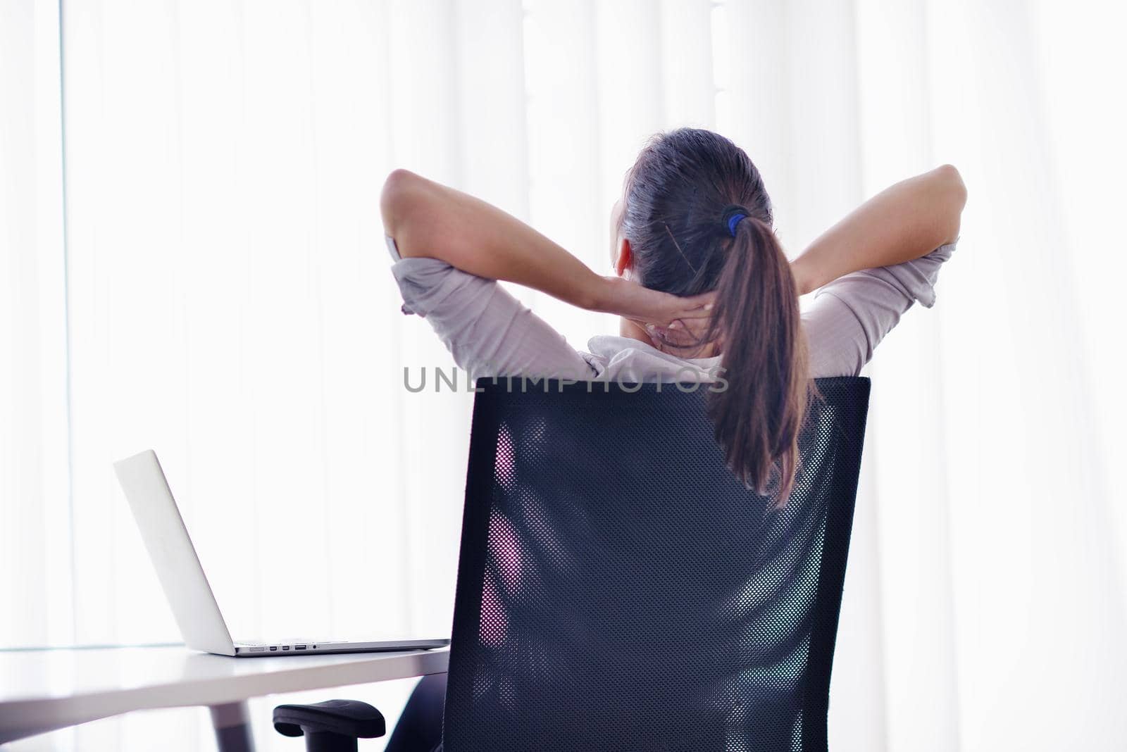 portrait of Young pretty business woman work on  notebook computer  in the bright modern office indoors