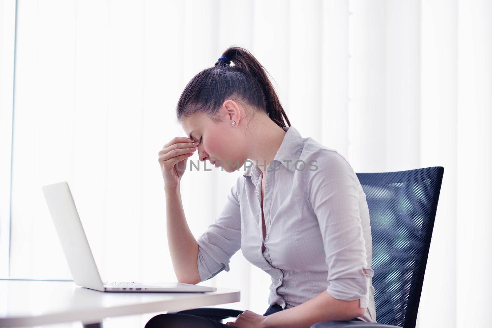 portrait of Young pretty business woman work on  notebook computer  in the bright modern office indoors