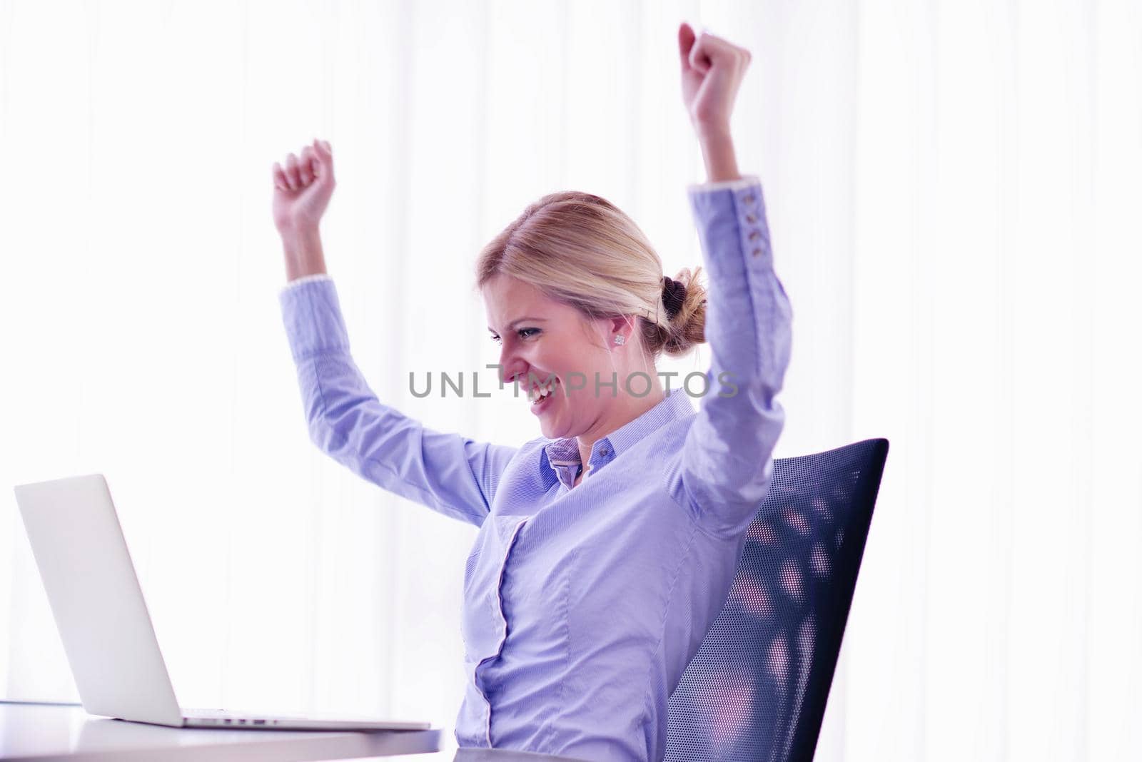 portrait of Young pretty business woman work on  notebook computer  in the bright modern office indoors