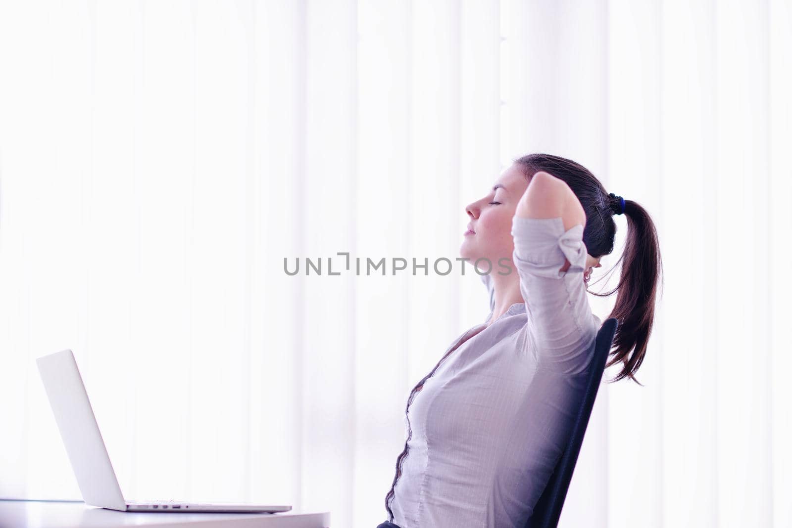 portrait of Young pretty business woman work on  notebook computer  in the bright modern office indoors