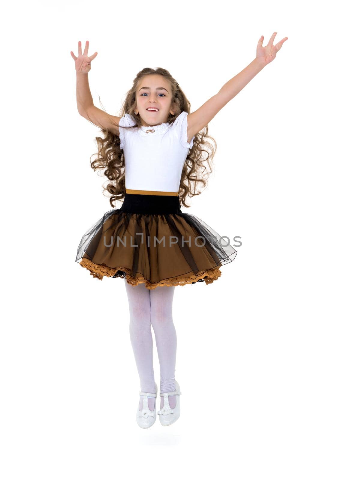 A little girl is jumping and waving her hands. The concept of a happy childhood, outdoor recreation. Isolated on white background.