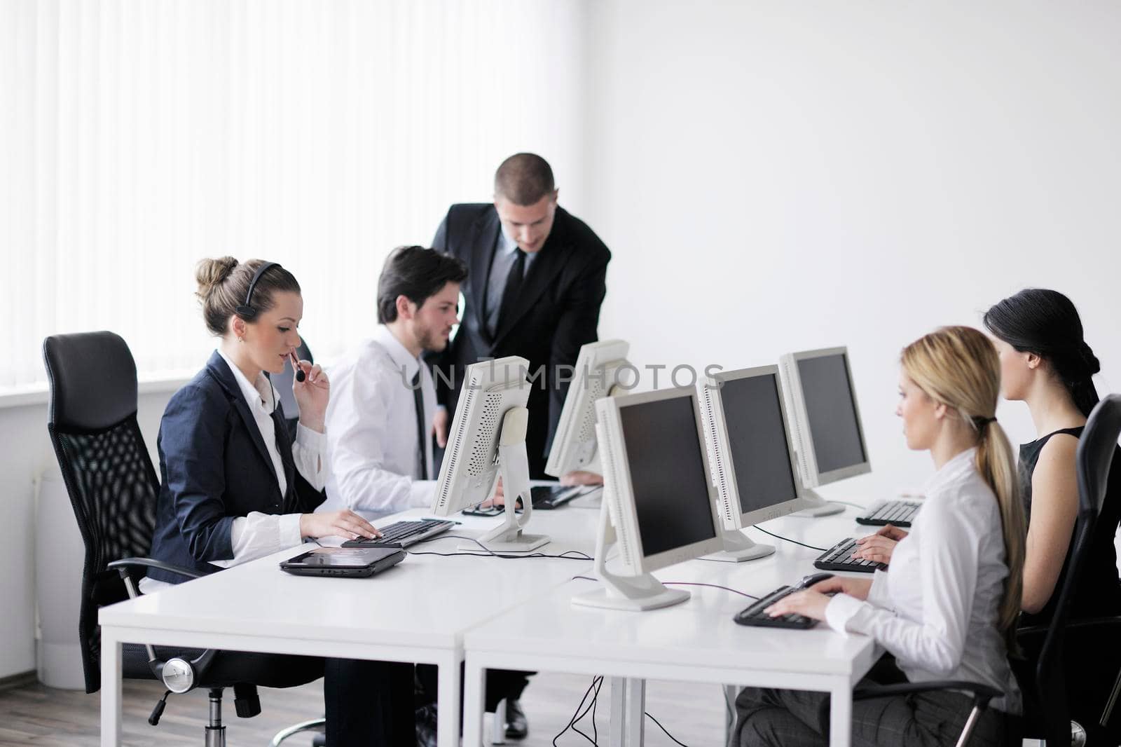 business people group working in customer and help desk office by dotshock