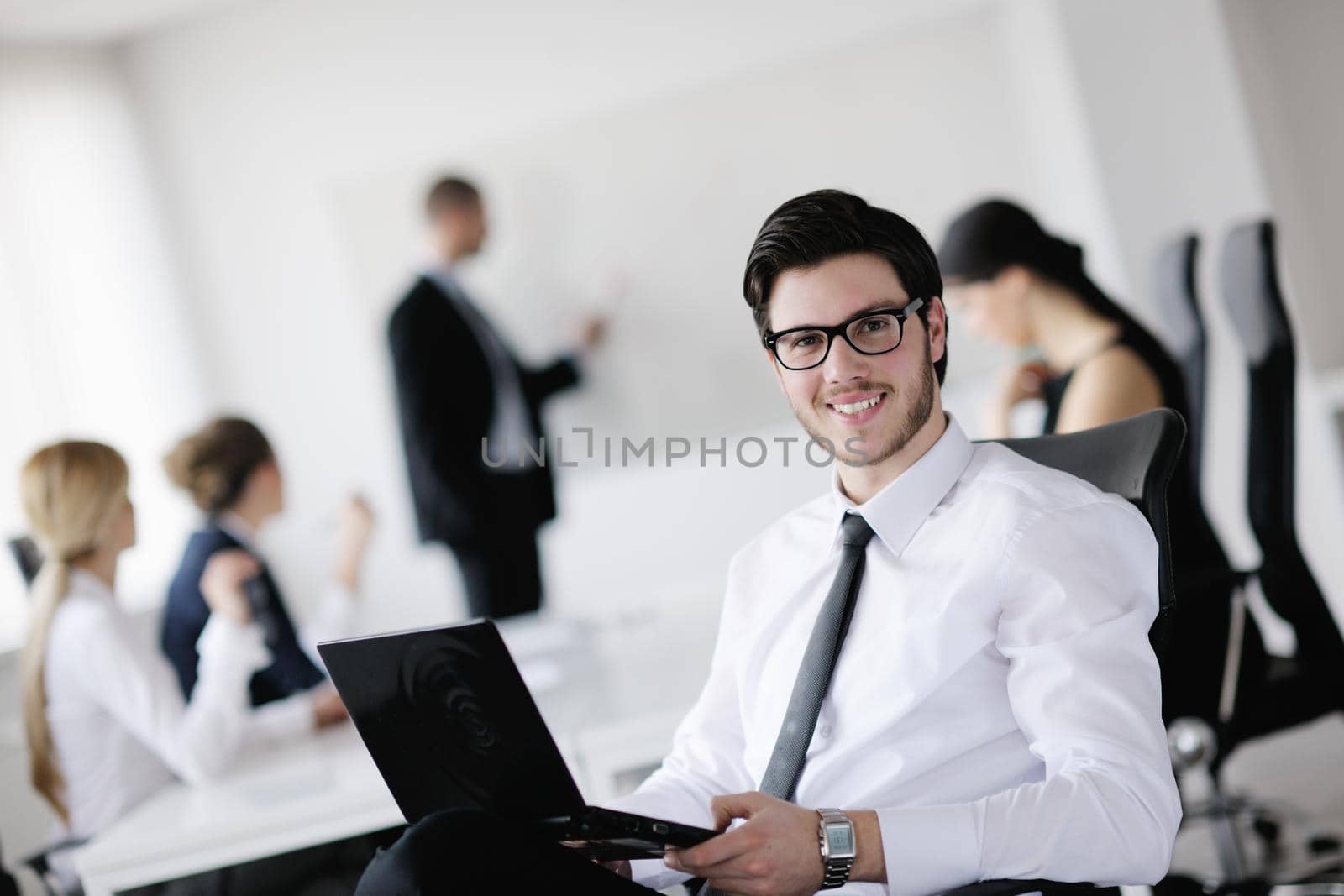Portrait of a handsome young business man with colleagues in background by dotshock