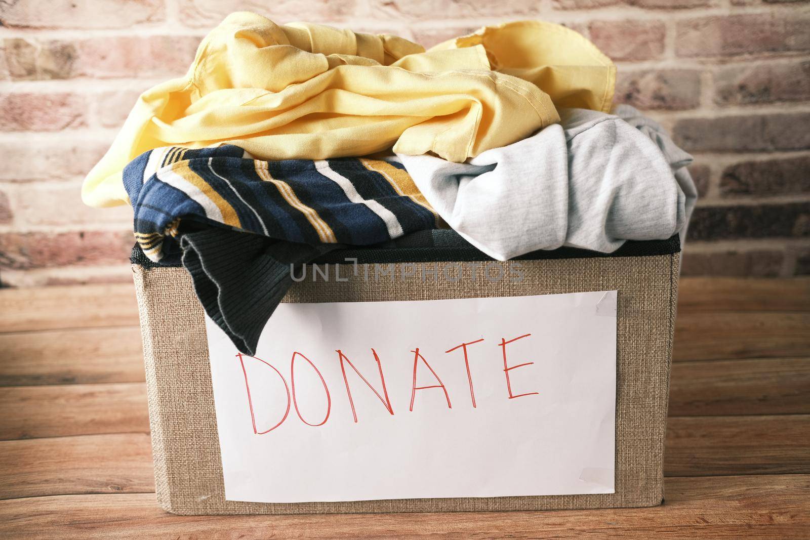 Donation box with donation clothes on a wooden background