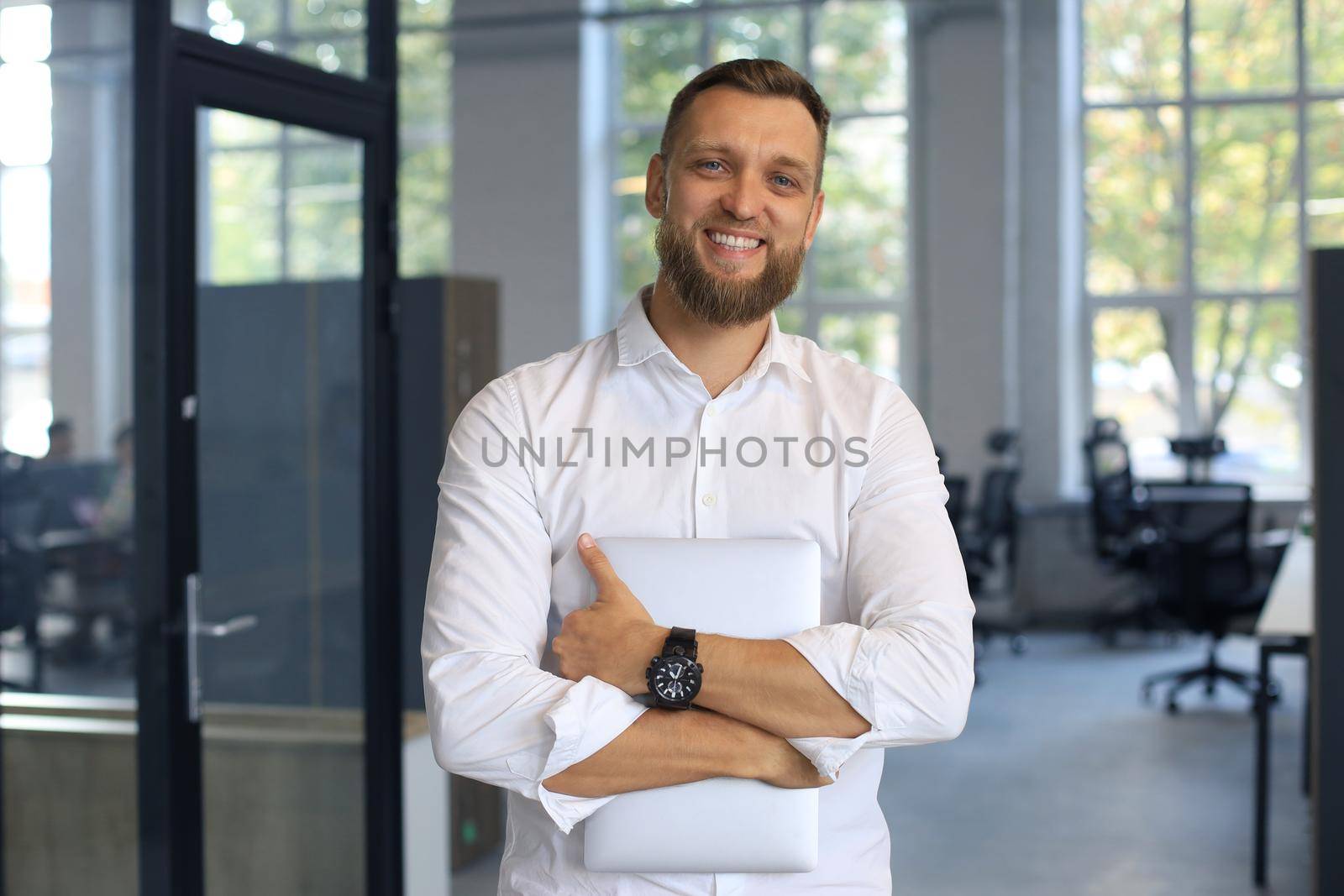 Young handsome businessman smiling in an office environment