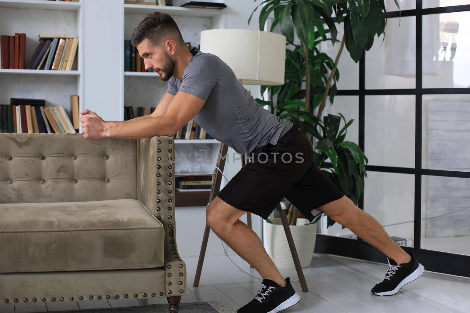 Handsome man doing sport exercise at home during quarantine. Concept of healthy life