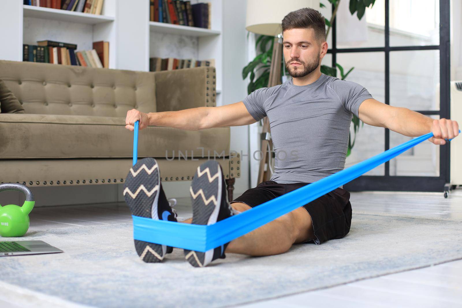 Handsome man doing sport exercise at home during quarantine. Concept of healthy life