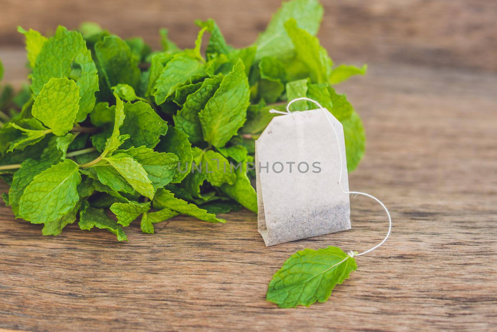 Tea bags on wooden background with fresh melissa, mint. Tea with mint concept by galitskaya