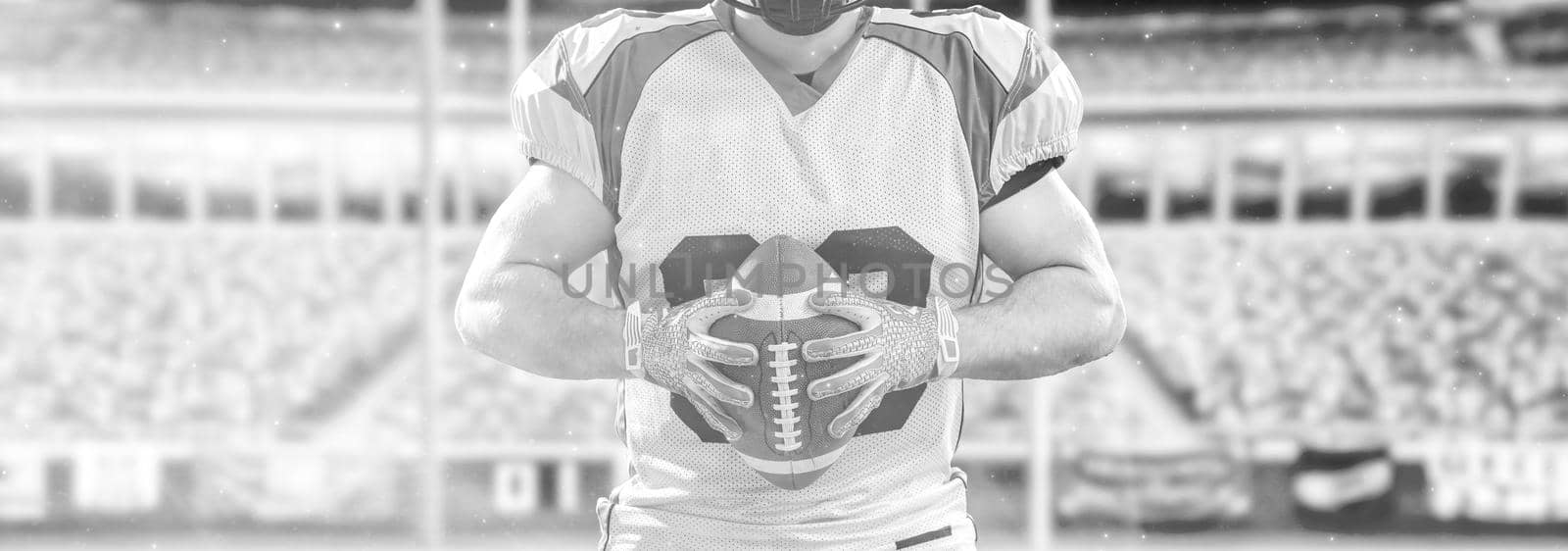 Closeup Portrait of a strong muscular American Football Player on big modern stadium field with lights and flares