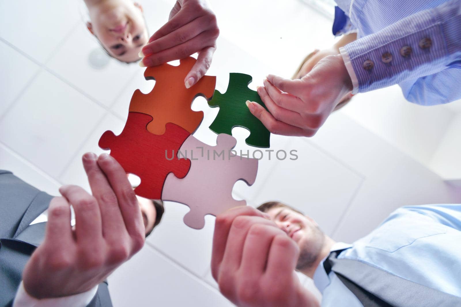 Group of business people assembling jigsaw puzzle and represent team support and help concept