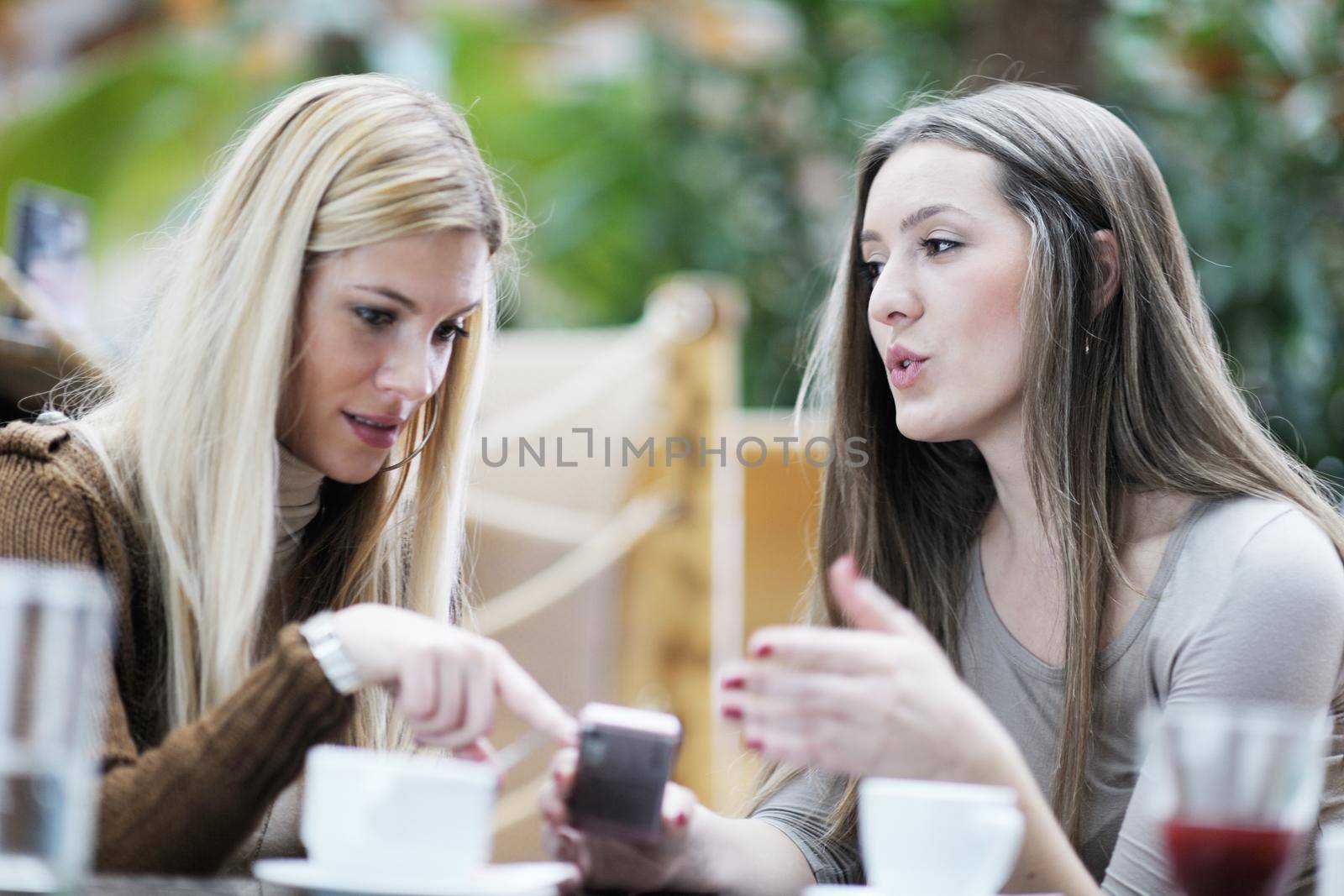 very cute smiling women drinking a coffee sitting inside in cafe restaurant