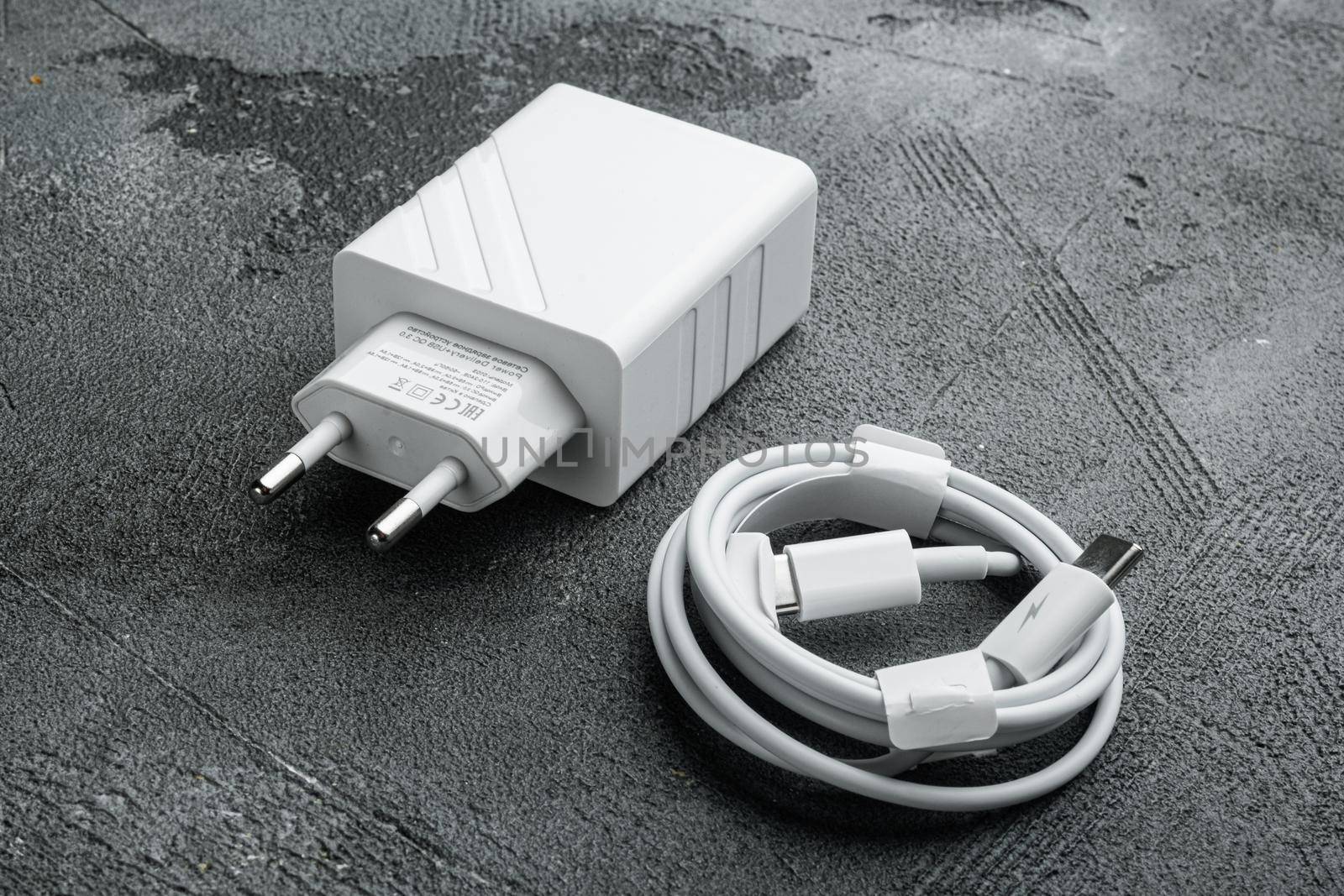 Adapter and USB Cable new package set, on gray stone table background