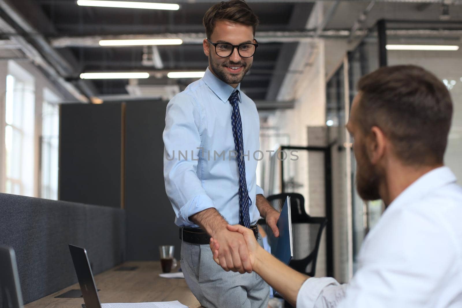 Two business colleagues shaking hands during meeting