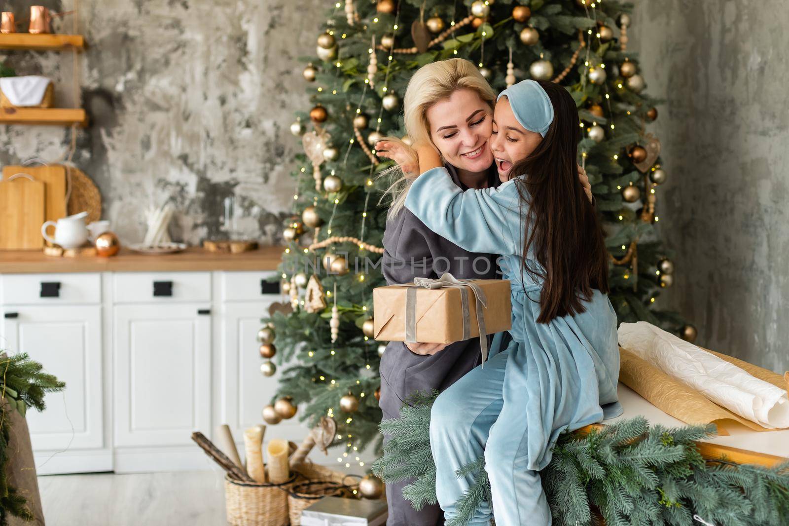 family, children, christmas, x-mas and happy people concept - hugging mother and daughter.