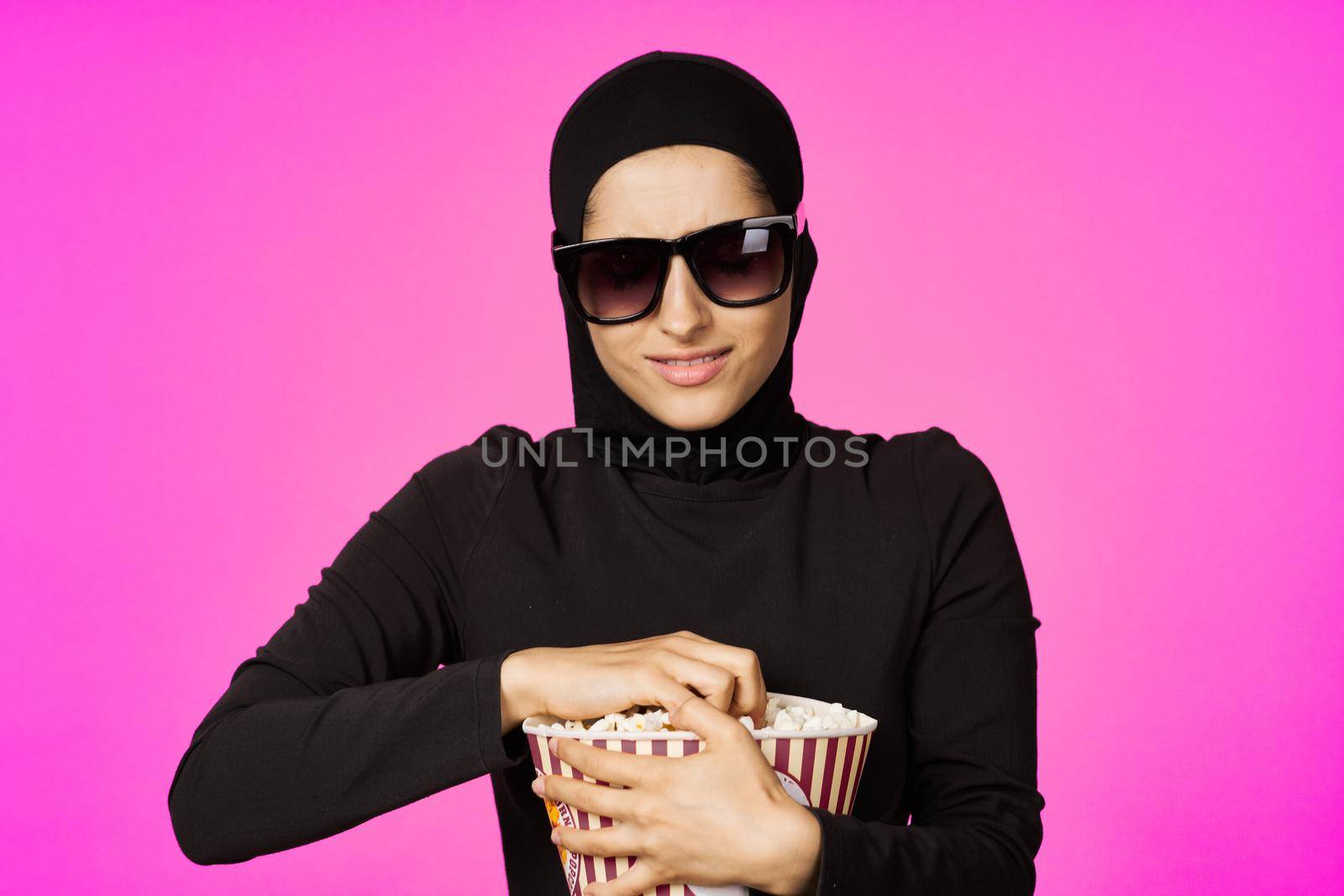Muslim woman entertainment cinema popcorn fashion model ethnicity. High quality photo