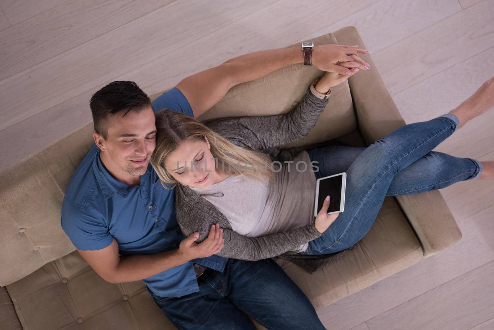 youg couple in living room with tablet top view by dotshock
