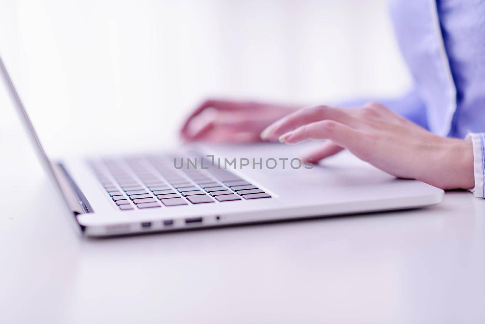 portrait of Young pretty business woman work on  notebook computer  in the bright modern office indoors