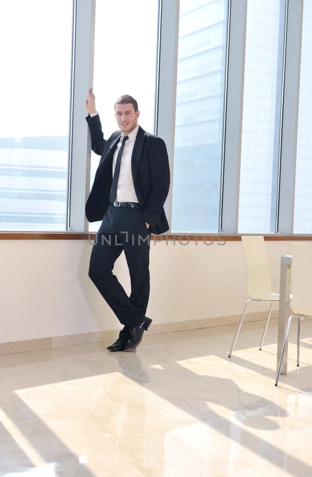 young business man lawyer with laptop alone in big bright   conference room