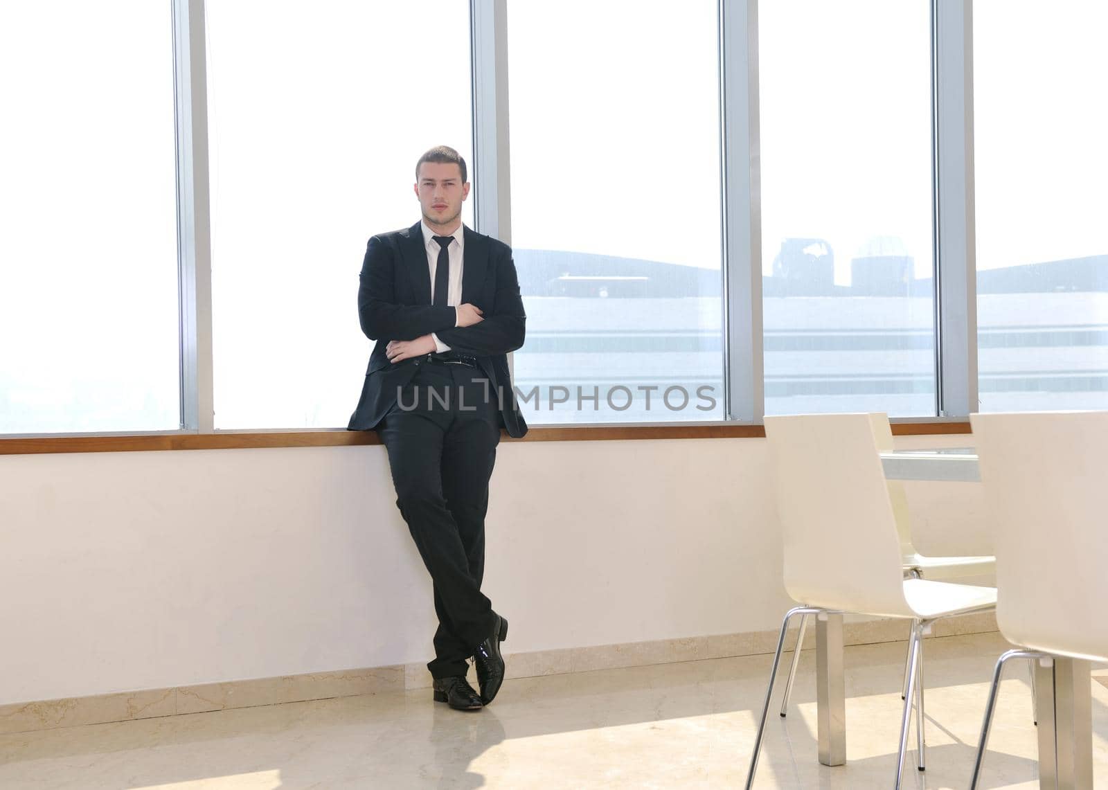 young business man lawyer with laptop alone in big bright   conference room